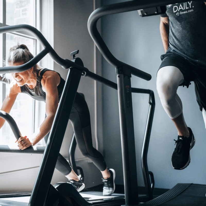 A man and a woman working out on treadmills | Ultimate Nutrition