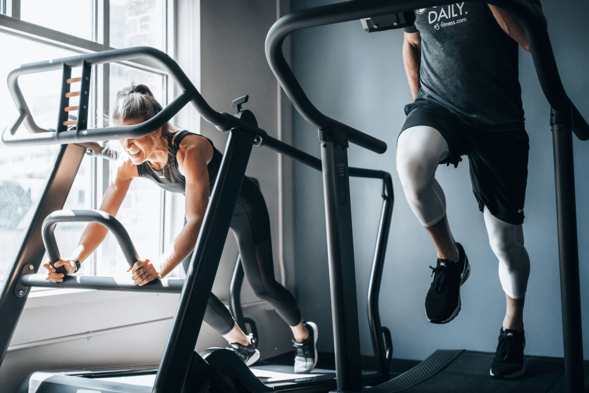 A man and a woman working out on treadmills | Ultimate Nutrition