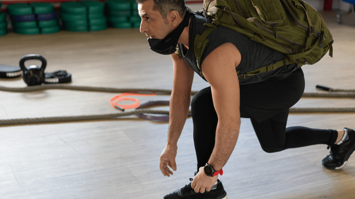 A man with ruck sack kneeling down | Ultimate Nutrition