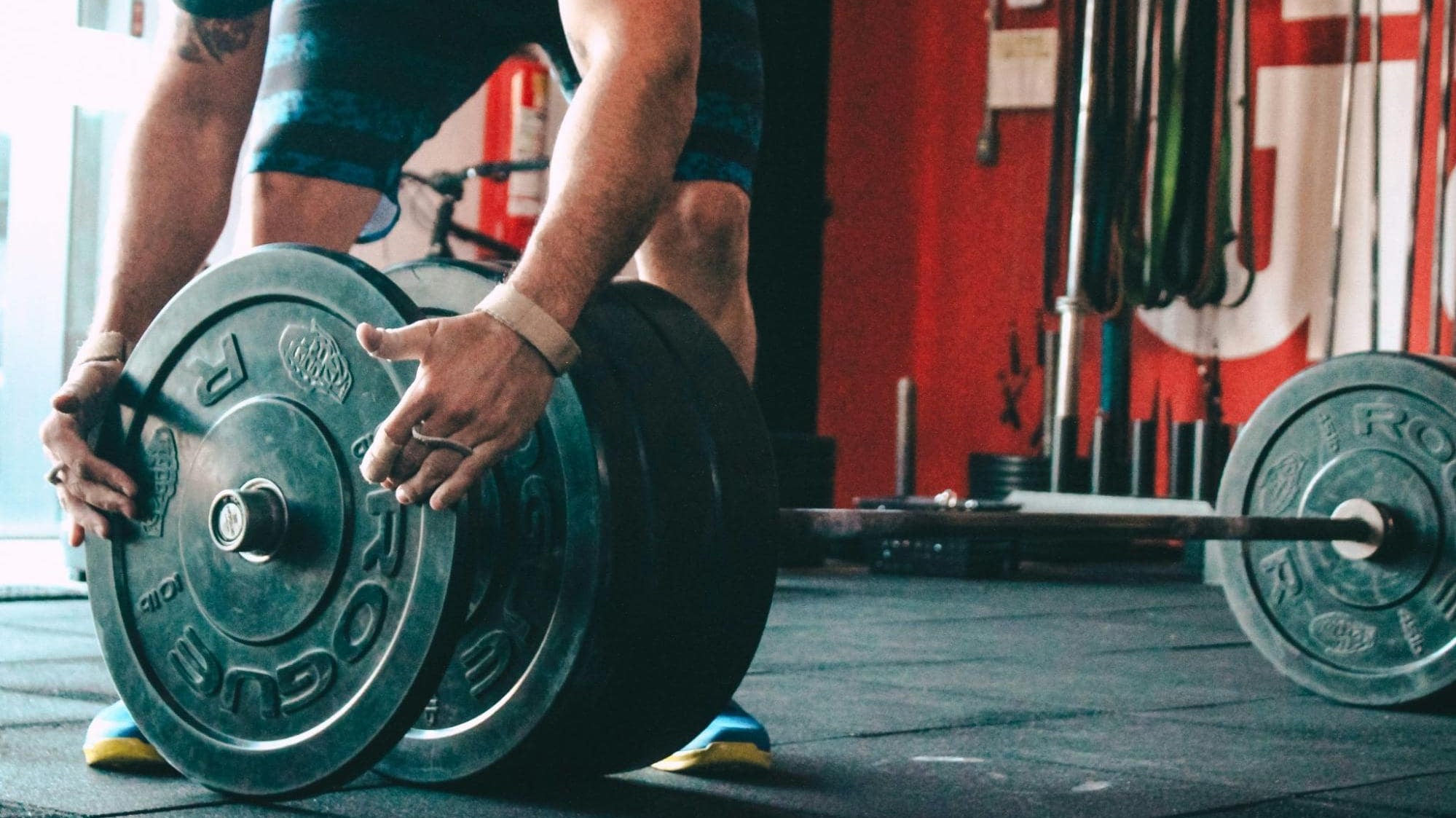 Man adding weight plate to barbell
