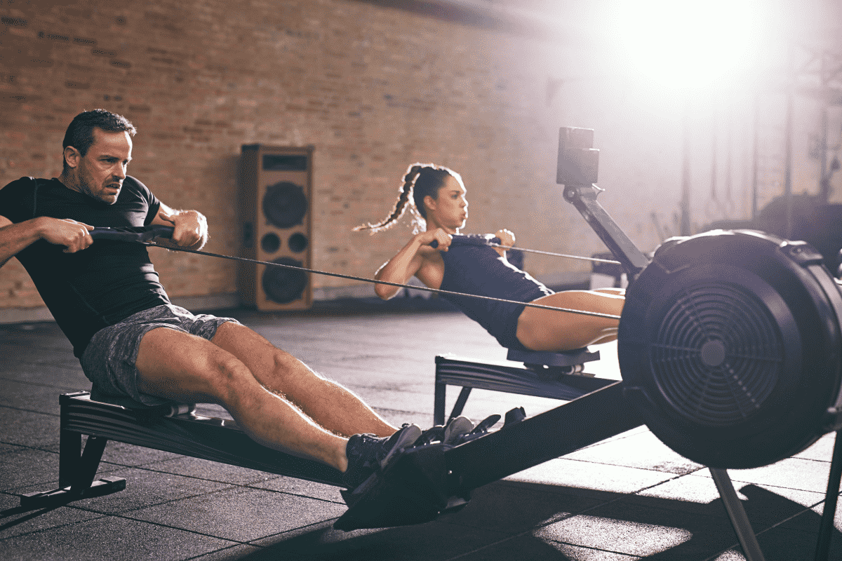 A man and a woman performing a rowing workout | Ultimate Nutrition