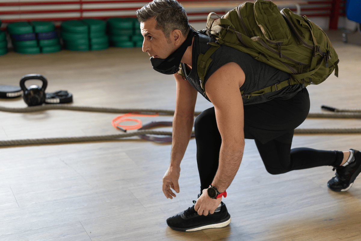 A man with ruck sack kneeling down | Ultimate Nutrition
