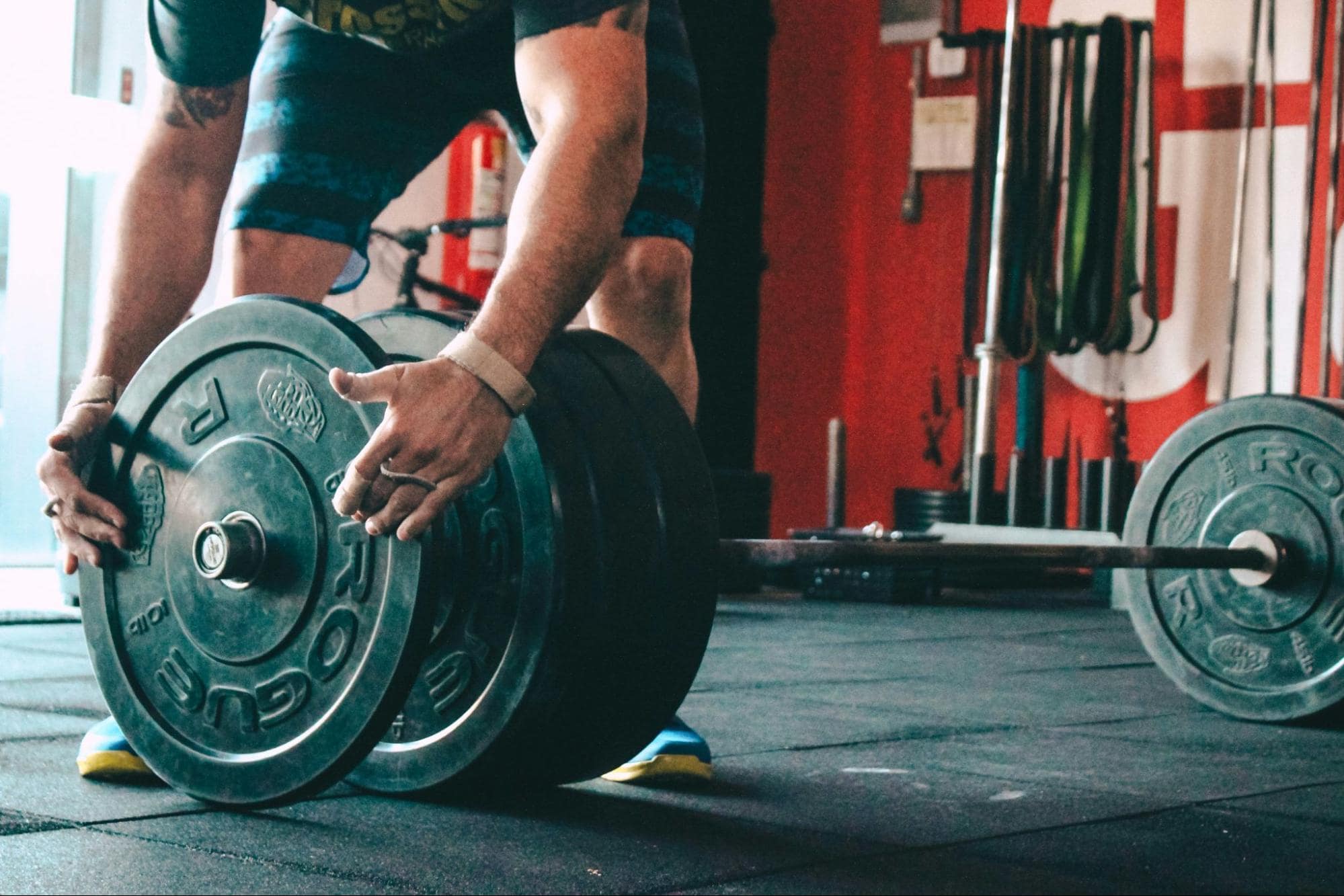 Man adding weight plate to barbell 